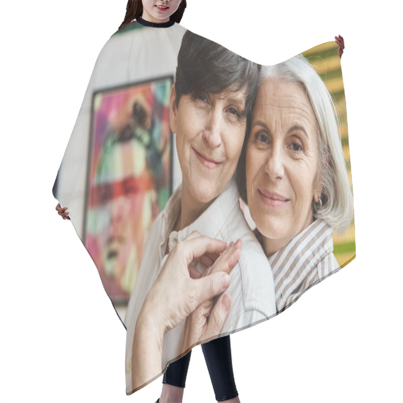 Personality  Two Women Hugging In Front Of Paintings In An Art Studio. Hair Cutting Cape