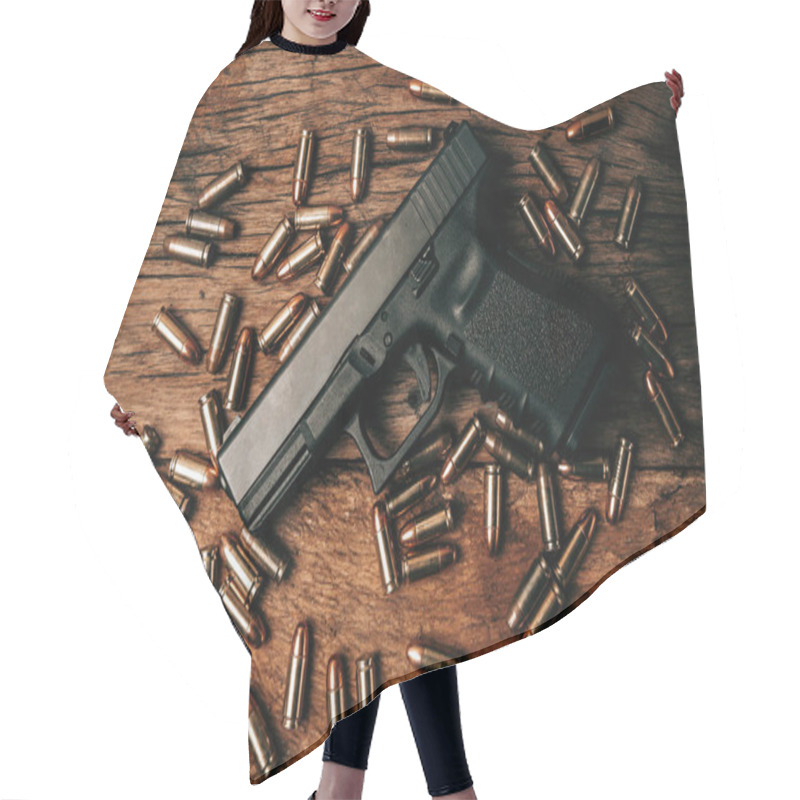 Personality  Portrait Of A Black 9mm Pistol On An Old Wooden Floor With 9mm Ammunition Next To It. Top View Hair Cutting Cape