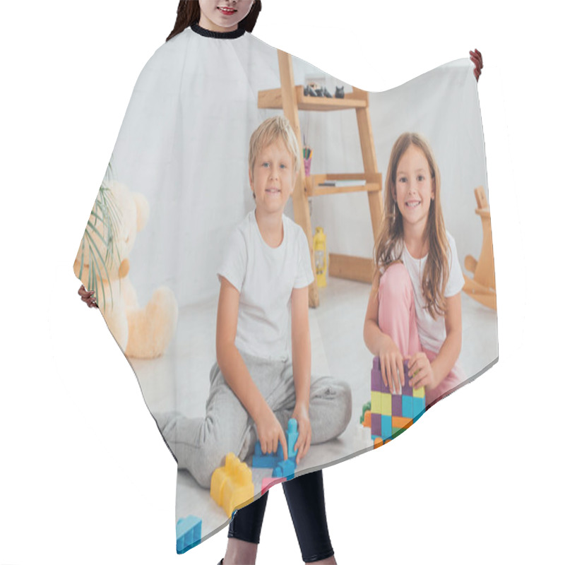 Personality  Excited Brother And Sister In Pajamas Sitting On Floor Near Building Blocks And Looking At Camera Hair Cutting Cape