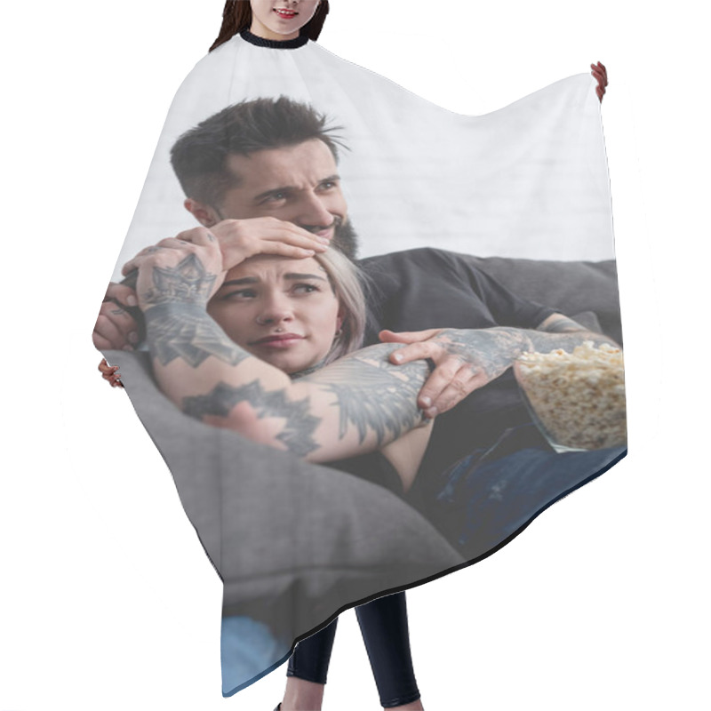 Personality  Scared Tattooed Couple Watching Horror Movie On Sofa At Home Hair Cutting Cape