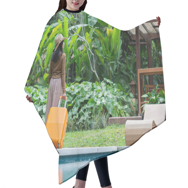 Personality  A Woman Walking By A Poolside With An Orange Suitcase, Wearing A Hat And Stylish Outfit. The Background Features Lush Greenery And A Wooden Structure, Creating A Tropical Vacation Vibe. Hair Cutting Cape