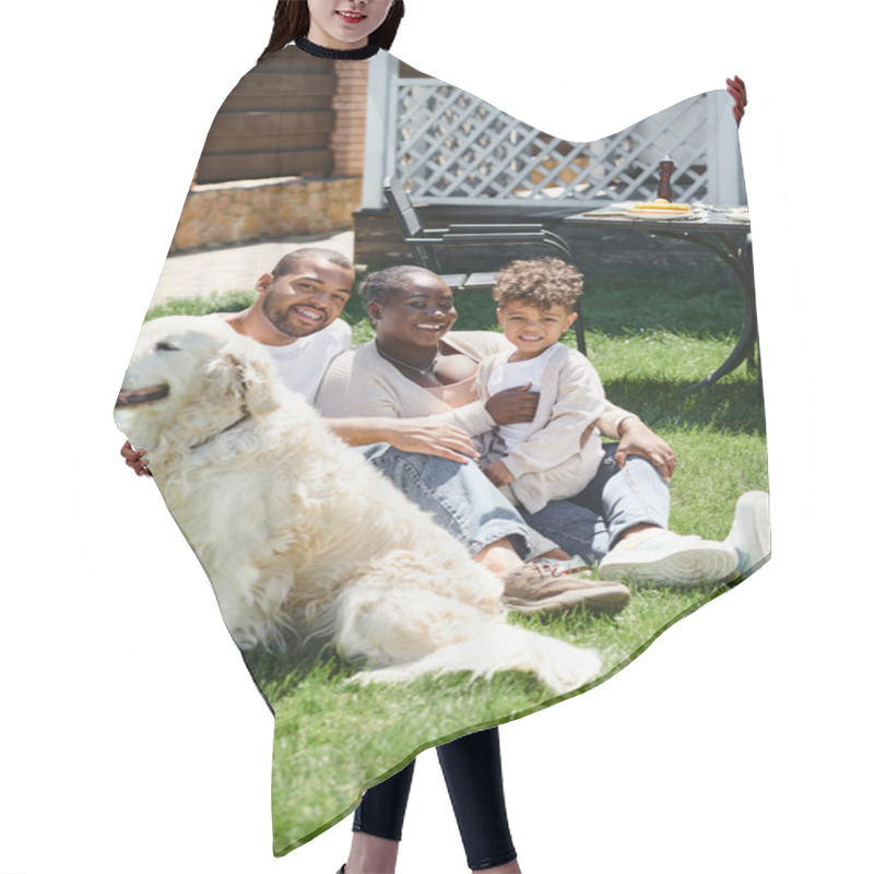 Personality  Family Portrait Of Joyful African American Parents And Son Smiling And Sitting On Lawn Near Dog Hair Cutting Cape