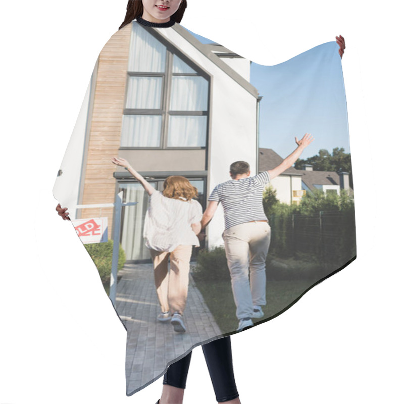 Personality  Back View Of Couple With Hands In Air Near Sign With Sold Lettering And Modern House Hair Cutting Cape