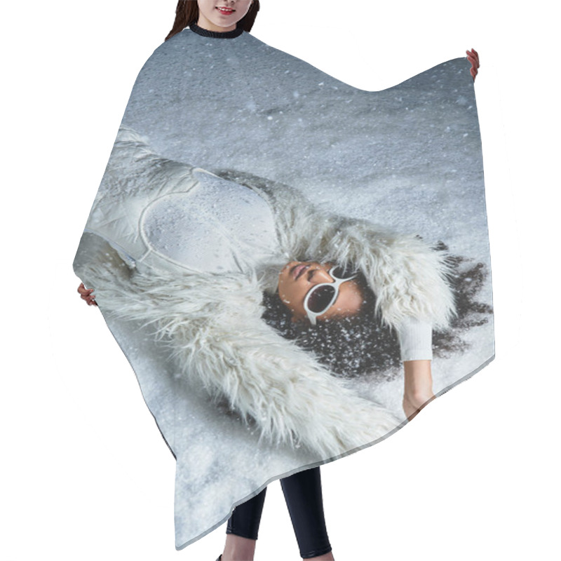 Personality  A Stylish African American Woman Relaxes In The Snow Wearing A White Ski Ensemble And Faux Fur Coat. Hair Cutting Cape