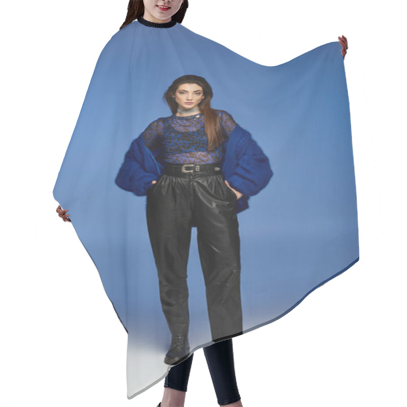 Personality  A Woman In A Blue Jacket And Black Pants Poses Against A Blue Backdrop. Hair Cutting Cape