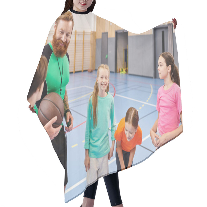 Personality  A Man Teacher Holds A Basketball While A Diverse Group Of Children Stand Around Him In A Bright, Lively Classroom Setting. Hair Cutting Cape