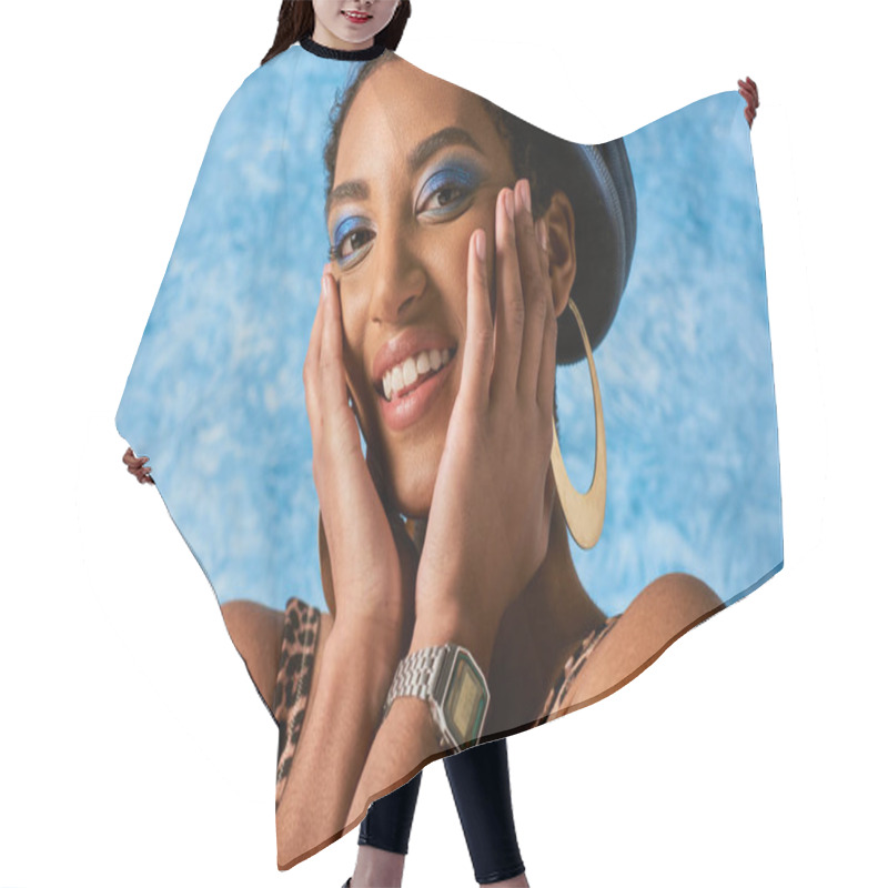 Personality  Portrait Of Joyful African American Model With Vivid Makeup Posing In Golden Earrings And Denim Beret While Looking At Camera On Blue Textured Background, Stylish Denim Attire Hair Cutting Cape