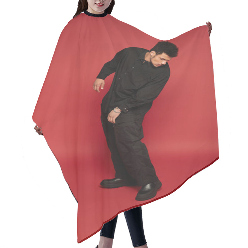 Personality  Stylish Young Man Dressed In Black Striking A Casual Pose In A Vivid Red Setting. Hair Cutting Cape