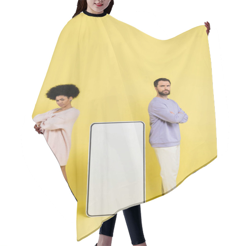 Personality  Full Length Of Displeased Interracial Couple Standing With Crossed Arms Near Huge Phone Template On Yellow Background Hair Cutting Cape