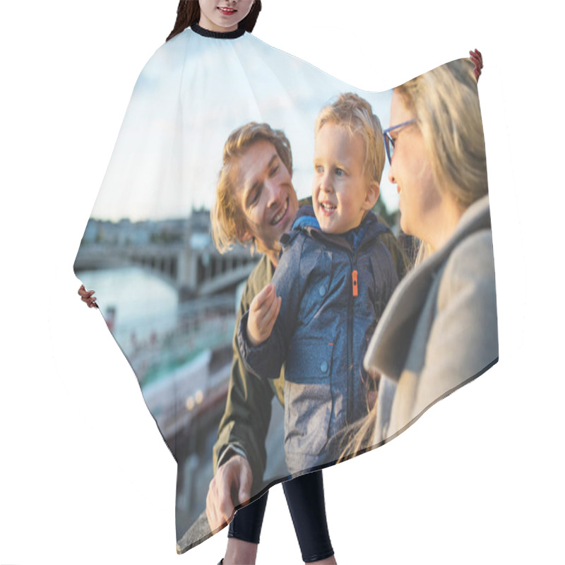 Personality  Young Parents With Their Toddler Son Standing Outdoors By The River In City. Hair Cutting Cape