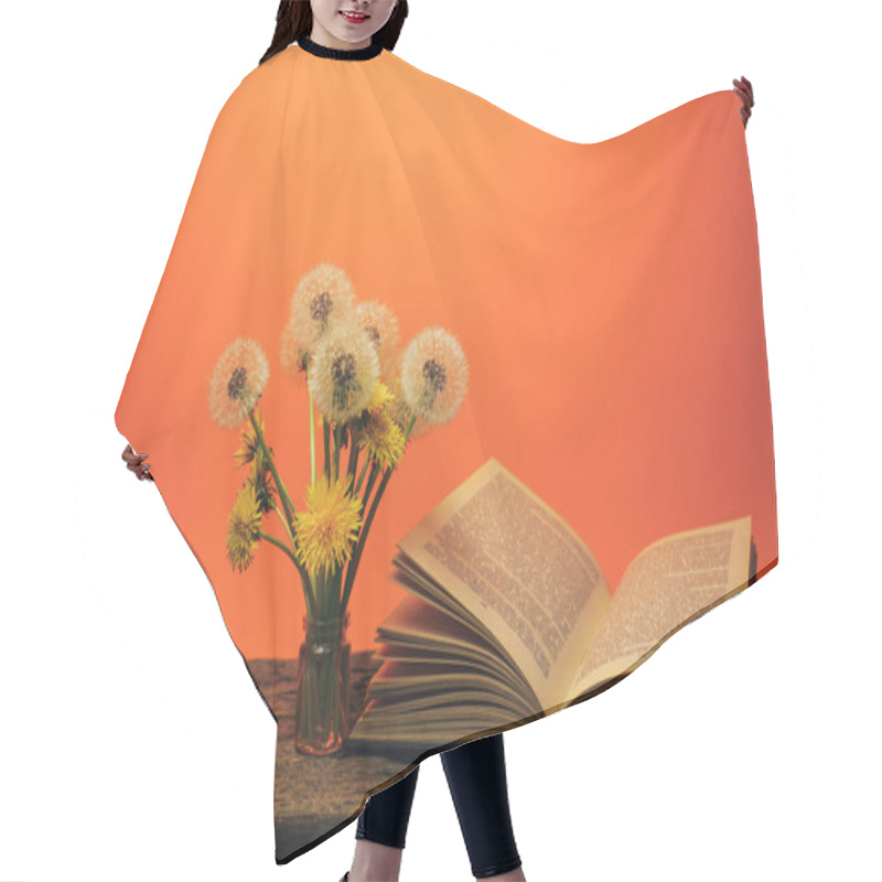 Personality  Open Book And  Yellow Flower Dandelion On A Old Oak Table And Coral Orange  Wall Background. Hair Cutting Cape