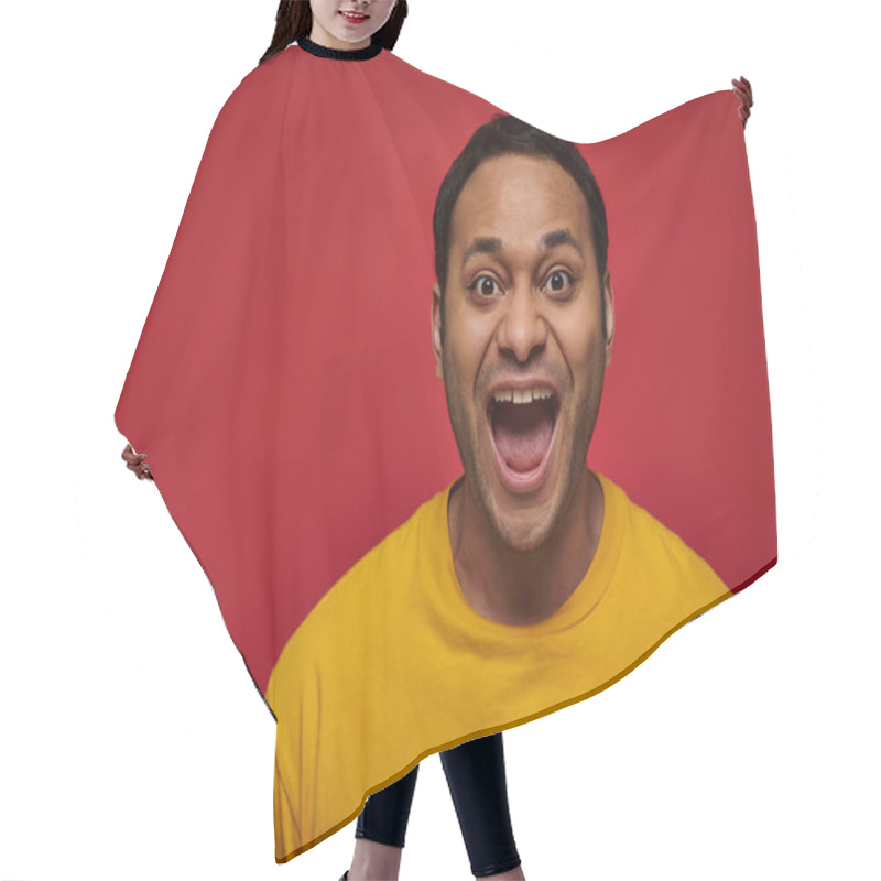 Personality  Positive Emotion, Excited Indian Man In Yellow T-shirt With Opened Mouth On Red Background Hair Cutting Cape