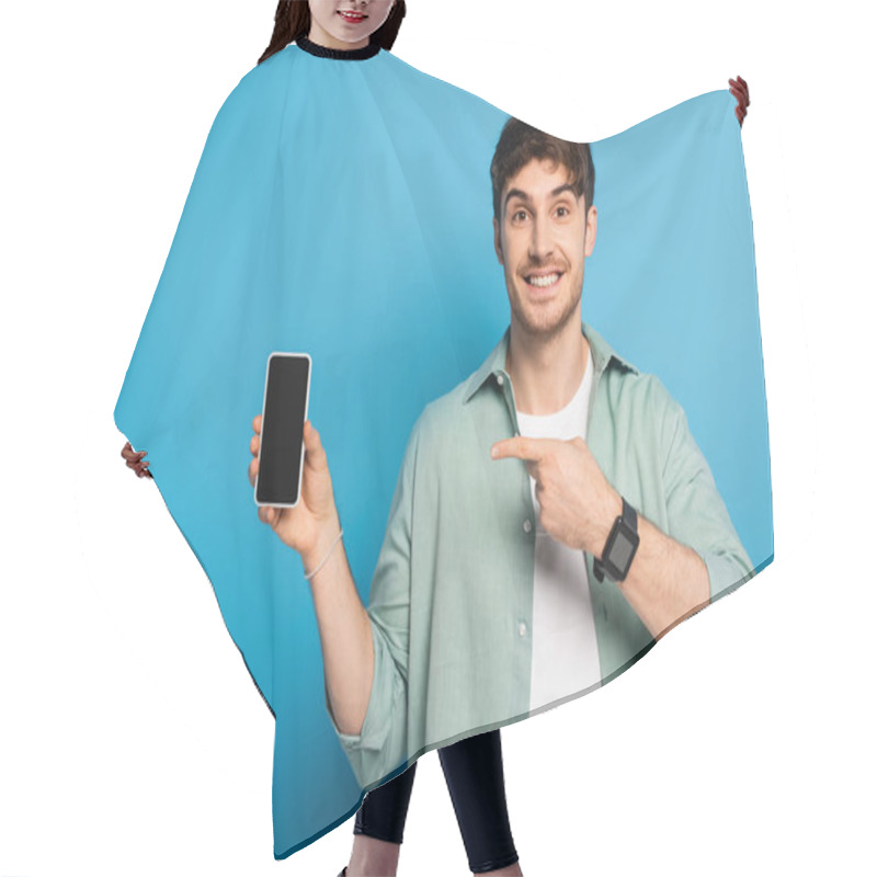 Personality  Happy Young Man Pointing At Smartphone With Blank Screen On Blue Hair Cutting Cape