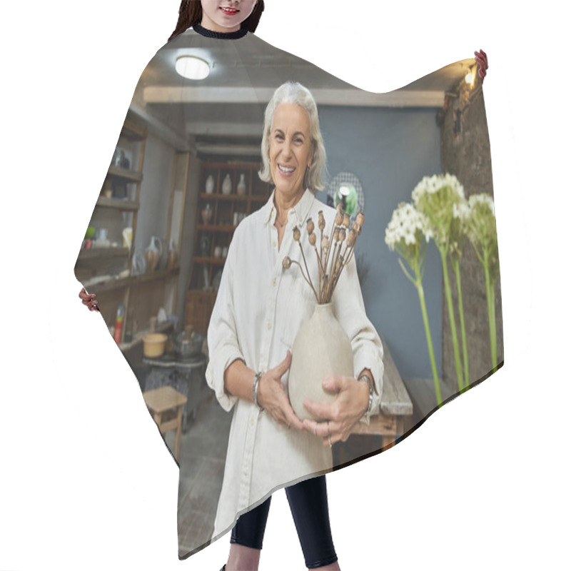 Personality  A Cheerful Mature Woman Holds A Handmade Vase, Displaying Creativity In Her Pottery Studio. Hair Cutting Cape