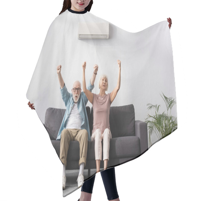 Personality  Positive Senior Couple Showing Yes Gesture Under Air Conditioner On Sofa At Home  Hair Cutting Cape