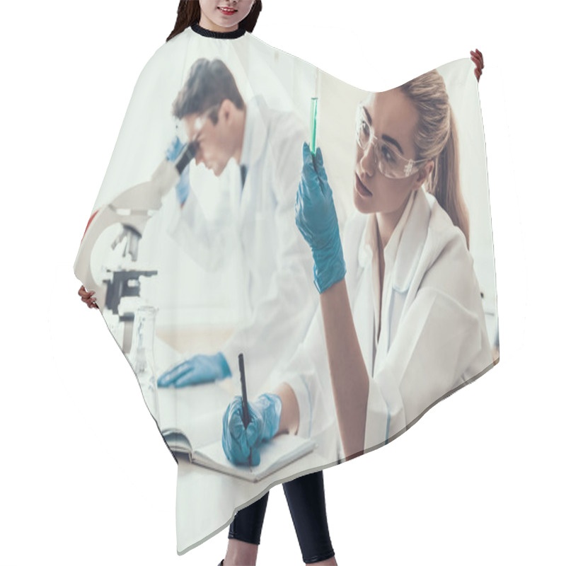 Personality  Young Scientists Examining Samples In Laboratory. Female Researcher Looking At Chemical Liquid Samples In Flasks While Male Scientist Using Microscope. Scientists At Work In Laboratory Hair Cutting Cape