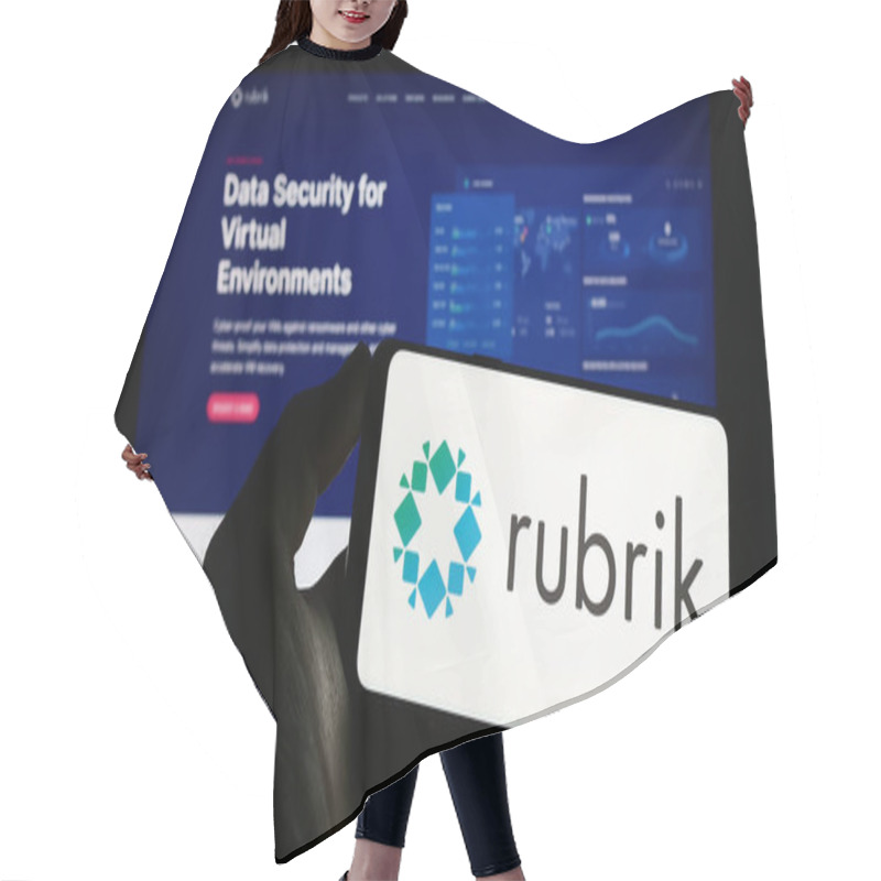 Personality  Stuttgart, Germany - 03-30-2023: Person Holding Cellphone With Logo Of US Data Security Company Rubrik Inc. On Screen In Front Of Business Webpage. Focus On Phone Display. Hair Cutting Cape