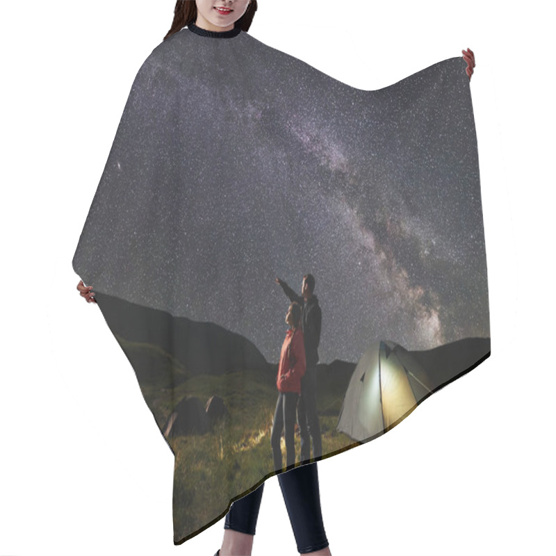 Personality  Male Shows Female Up On The Night Starry Sky At Milky Way. Happy Pair Backpackers Standing Near Illuminated Tent At Camping, Against The Backdrop Of The Mountains Covered By Greenery And The Lake. Hair Cutting Cape