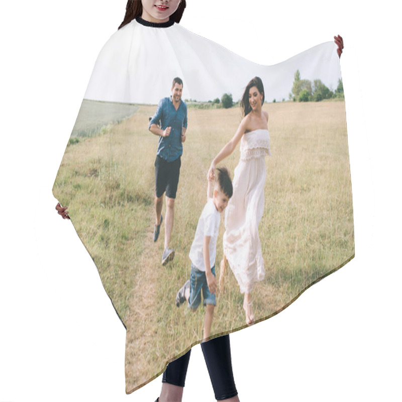 Personality  happy parents and son running on field hair cutting cape