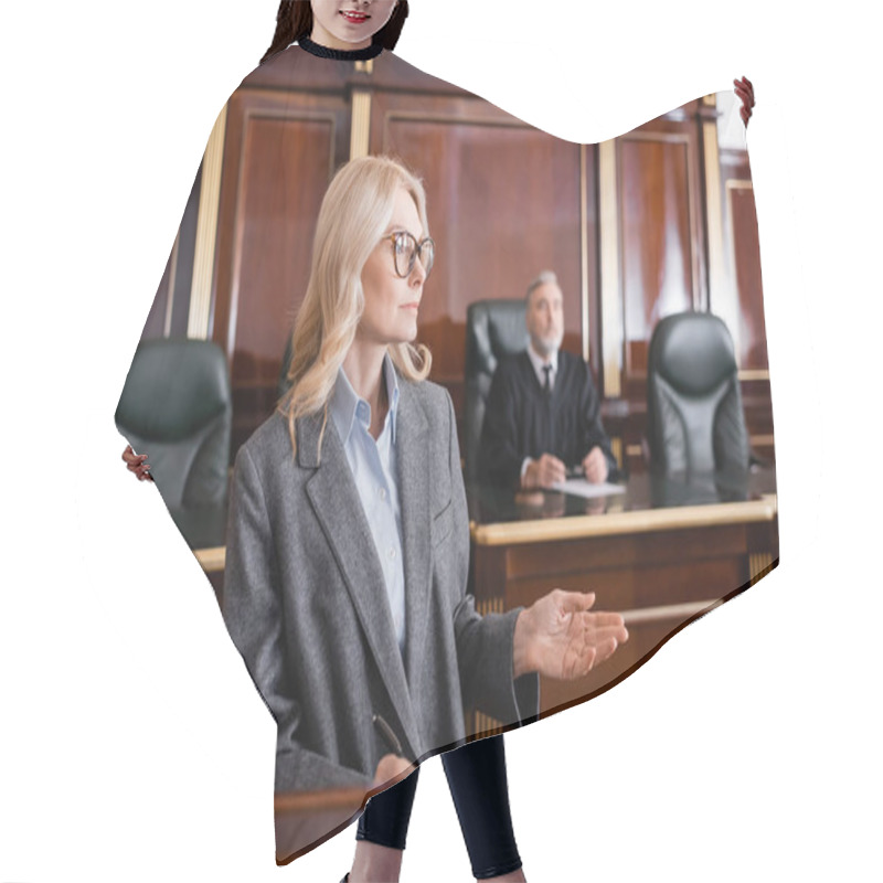 Personality   Blonde Advocate Pointing With Hand While Talking In Court Near Judge On Background Hair Cutting Cape