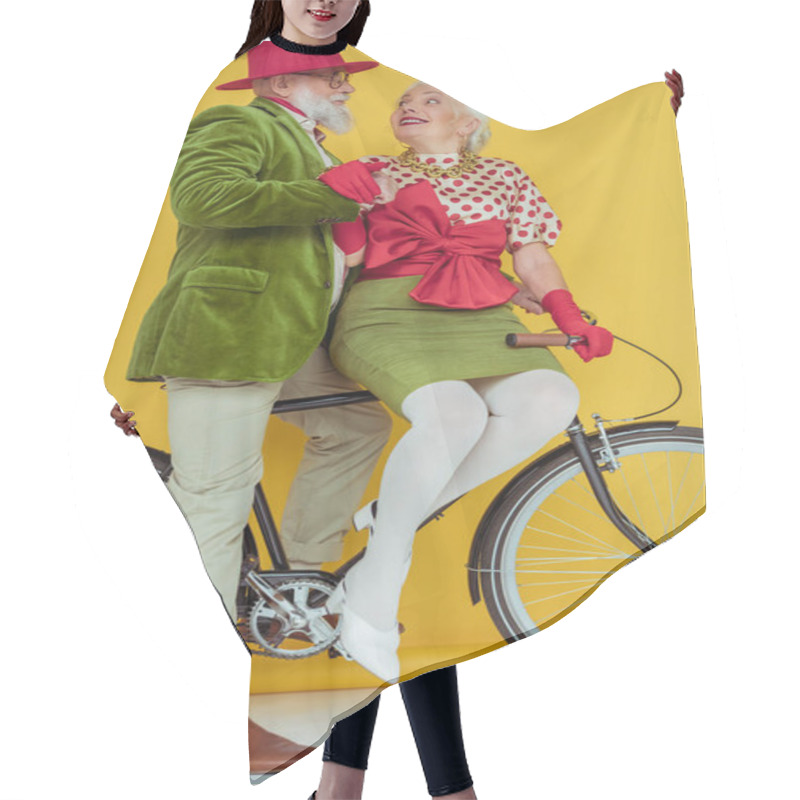 Personality  Fashionable Senior Couple Smiling At Each Other On Bicycle On White Surface On Yellow Background Hair Cutting Cape