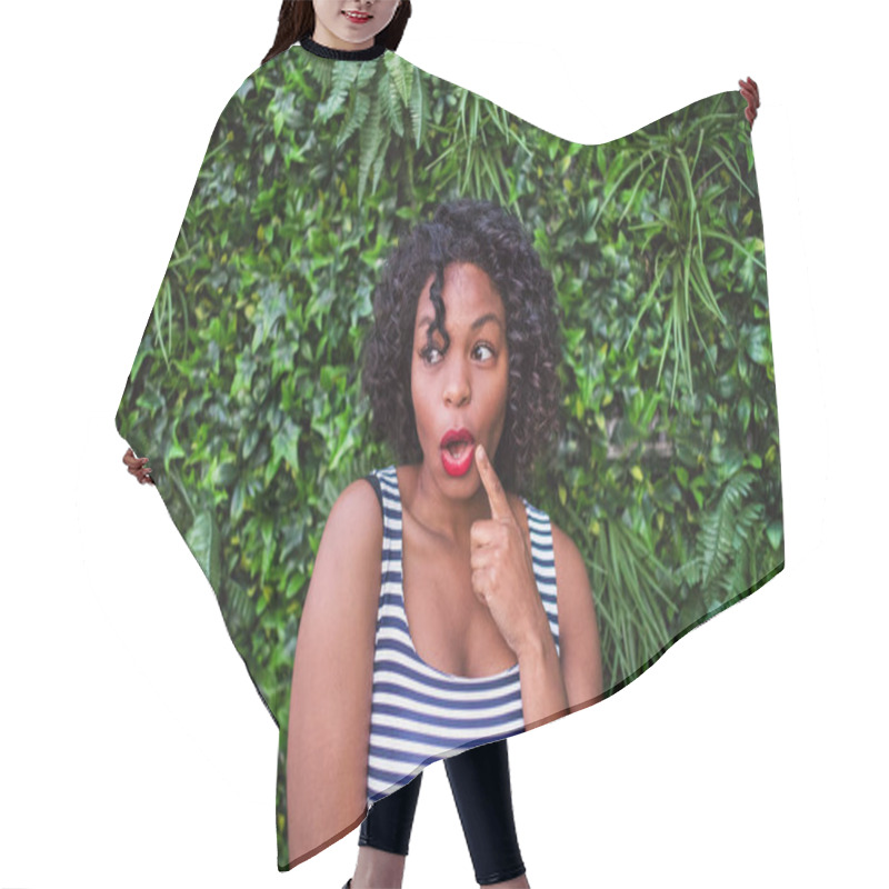 Personality  A Portrait Of A Black Woman Standing Against Green Background Of Bush Leaves. Hair Cutting Cape