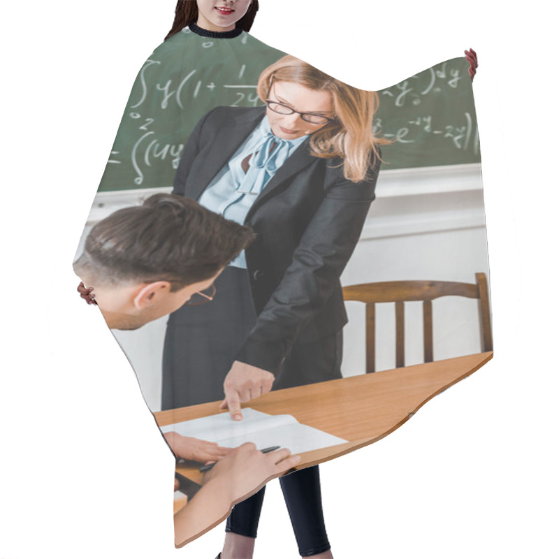 Personality  Female Teacher Pointing At Notebook Near Male Student  Hair Cutting Cape