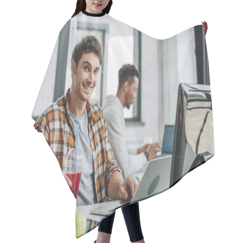 Personality  Cheerful Programmer Looking At Camera While Sitting Near African American Colleague Hair Cutting Cape