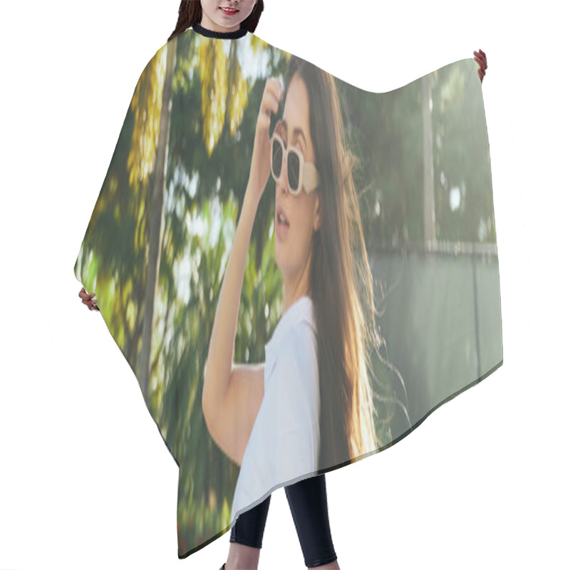 Personality  Captivating And Young Brunette Woman With Long Hair Standing In White T-shirt And Trendy Sunglasses Near Blurred And Green Palm Trees In Miami, Sunny Day, Travel, Vacation, Banner  Hair Cutting Cape