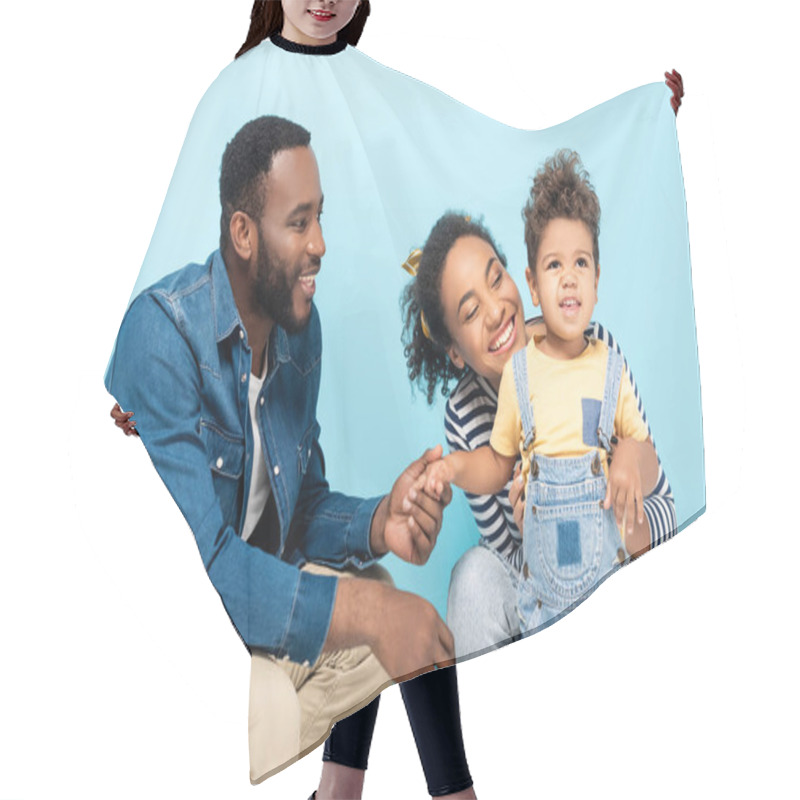 Personality  Smiling African American Man Holding Hand Of Cheerful Son Near Happy Wife Isolated On Blue Hair Cutting Cape