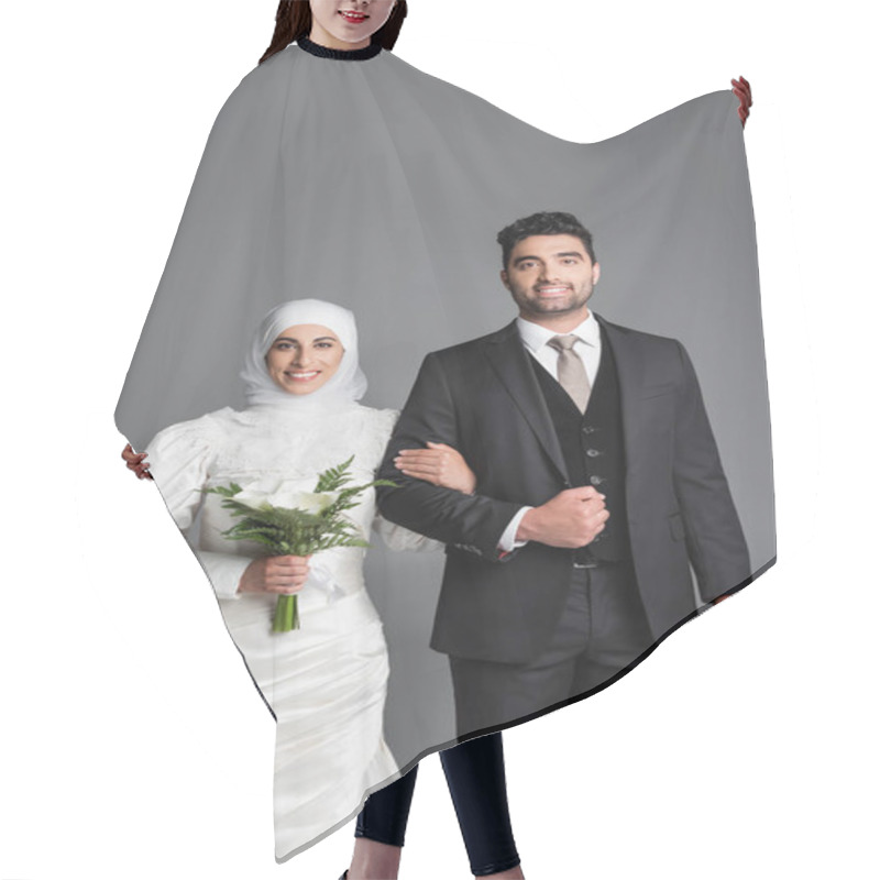 Personality  Portrait Of Happy Groom In Suit Standing Muslim Bride With Wedding Bouquet Of Calla Lily Flowers Isolated On Grey Hair Cutting Cape