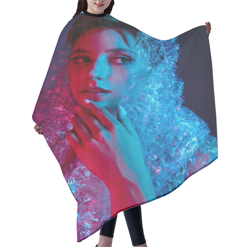 Personality  A Woman's Face Is Illuminated By Red And Blue Light, As She Is Wrapped In Plastic. Hair Cutting Cape