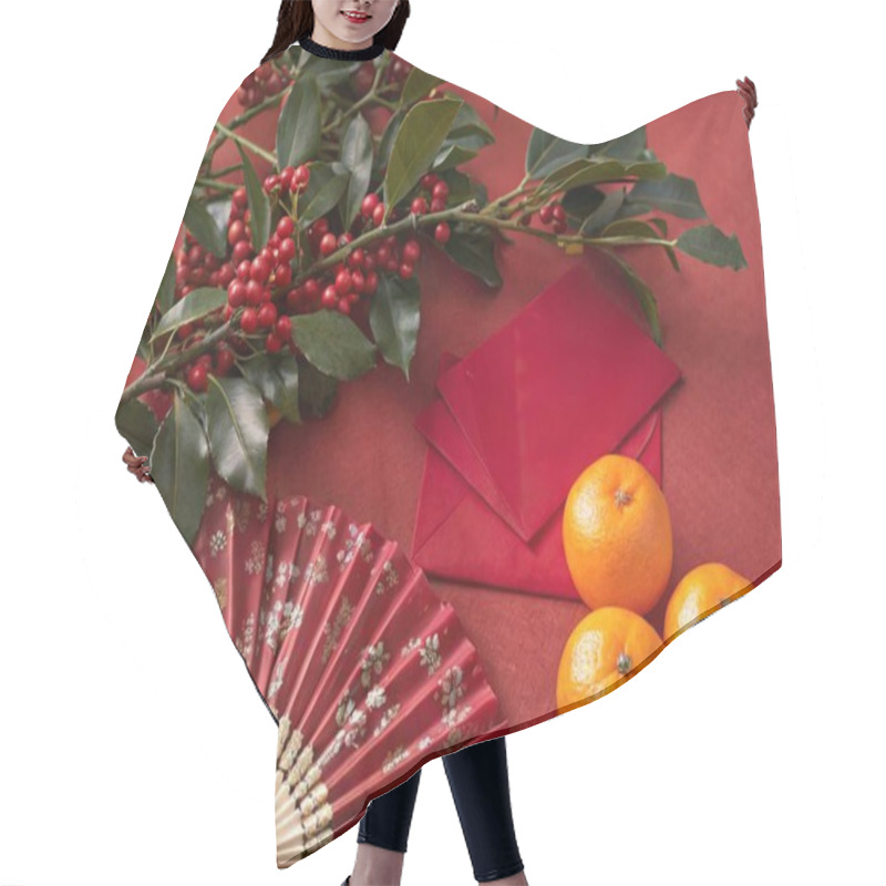 Personality  A Still Life Photo Featuring A Festive Scene With A Rich, Warm Color Palette. The Image Includes A Branch With Small Red Berries And Green Leaves, Envelopes In Rich Red, A Traditional Chinese-inspired Fan With Intricate Designs In Red, And Several Fr Hair Cutting Cape