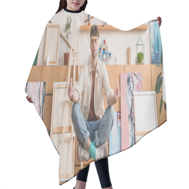 Personality  Panoramic Shot Of Artist With Closed Eyes Levitating In Lotus Pose In Gallery Hair Cutting Cape