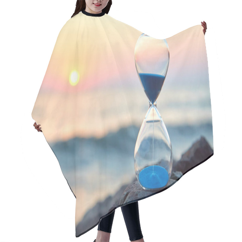 Personality  Hourglass With Sand Standing On Rock. Sunset Over Sea And Nature Landscape. Running Of Time And Relax Idea, Copy Space Hair Cutting Cape