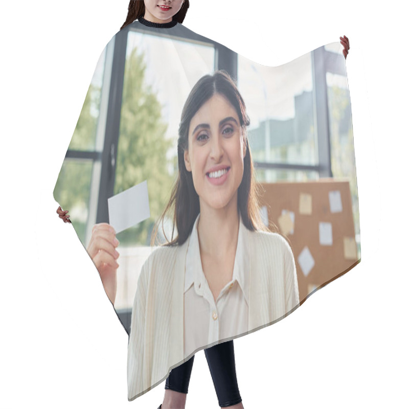 Personality  A Modern Businesswoman Holds Up A Business Card In Front Of A Window In A Sleek Office Space. Hair Cutting Cape