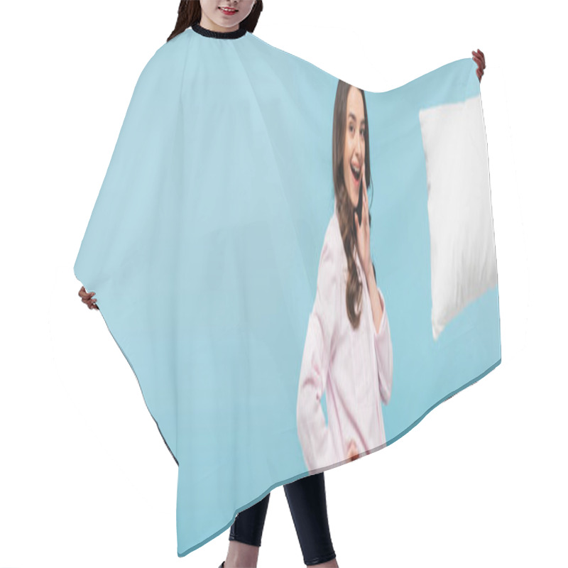 Personality  Excited Young Woman In Sleepwear Standing With Hand On Hip Near Levitating Pillow Isolated On Blue, Banner  Hair Cutting Cape