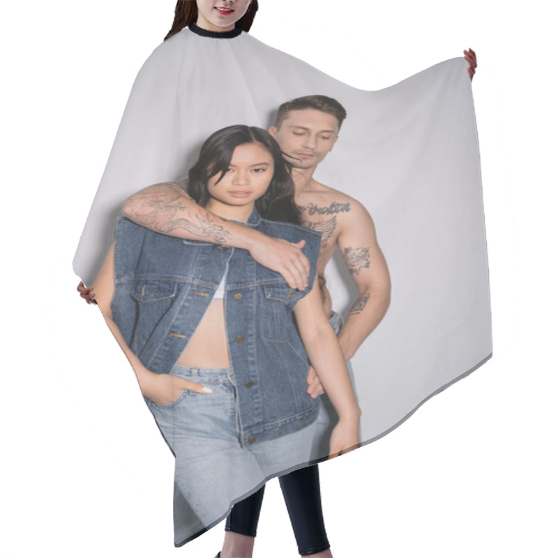 Personality  Shirtless Tattooed Man Embracing Asian Woman Posing With Hand In Pocket Of Jeans On Grey Background Hair Cutting Cape