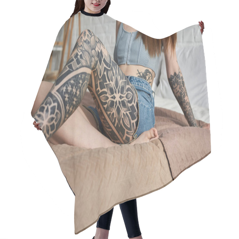 Personality  A Young Woman With Intricate Tattoos On Her Legs And Arms Relaxes On A Bed In A Modern Apartment. Hair Cutting Cape