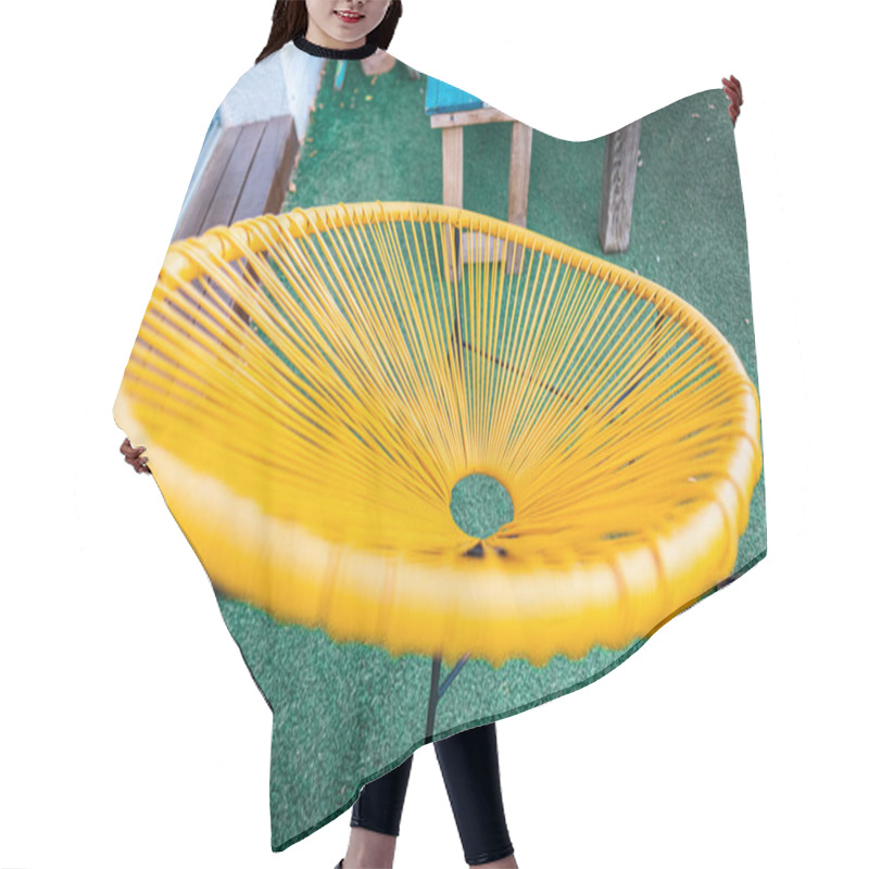 Personality  Bright Yellow Chair With A Modern Circular Design Displayed On A Green Patio, Accompanied By Rustic Wooden Table Outdoors, Illustrating Contrast Between Cheerful Hues And Natural Textures. Hair Cutting Cape