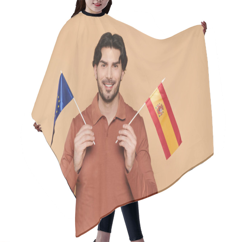 Personality  A Cheerful Young Man With Brunette Hair Proudly Holds The European And Spanish Flags. Hair Cutting Cape