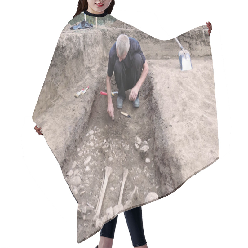 Personality  Archaeological Excavation. The Archaeologist In A Digger Process, Researching The Tomb, Human Bones, Part Of Skeleton And Skull In The Ground. Hands With Tools. Close Up, Outdoors, Copy Space. Hair Cutting Cape