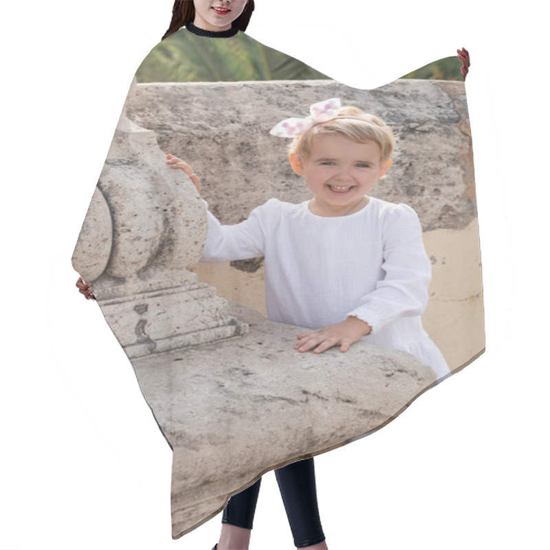 Personality  Positive Toddler Child In Summer Dress Looking At Camera Near Stone Puente Del Mar Bridge In Valencia Hair Cutting Cape