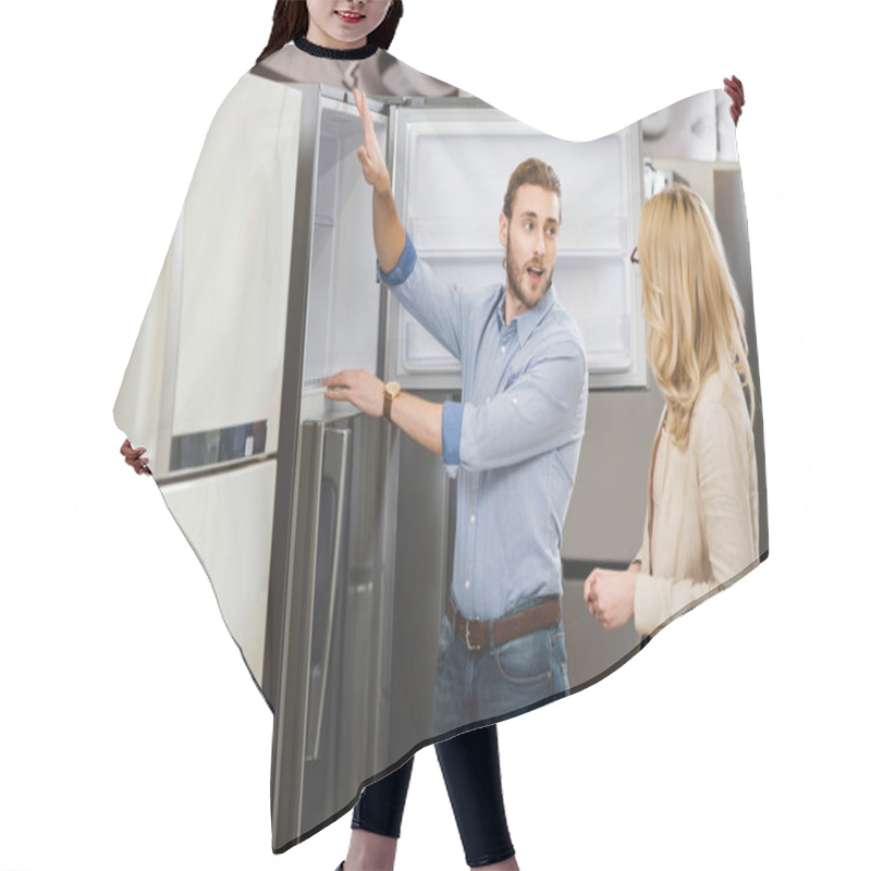 Personality  Consultant Talking With Woman And Showing Fridge In Home Appliance Store  Hair Cutting Cape