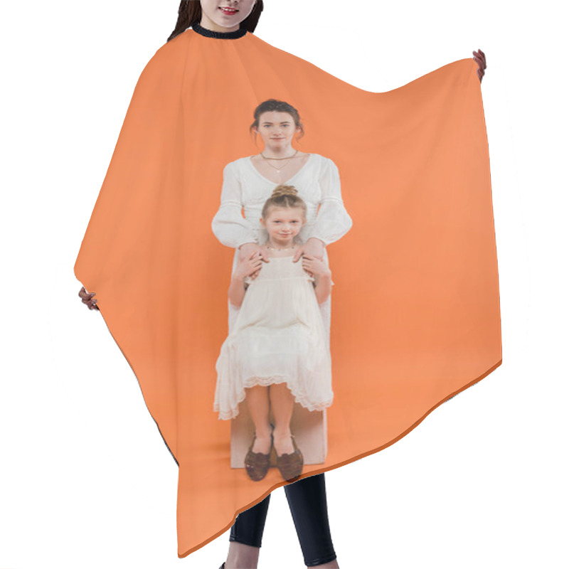 Personality  Motherly Love, Young Mother Hugging Daughter And Standing Together In White Sun Dresses On Orange Background, Family Fashion, Fashionable Woman And Girl, Female Bonding, Modern Parenting  Hair Cutting Cape