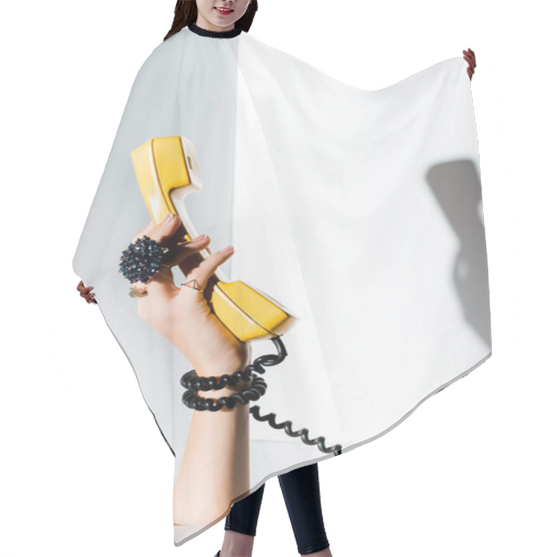 Personality  Cropped Image Of Girl Holding Yellow Handset Of Retro Telephone In Hand Through Hole On White Hair Cutting Cape