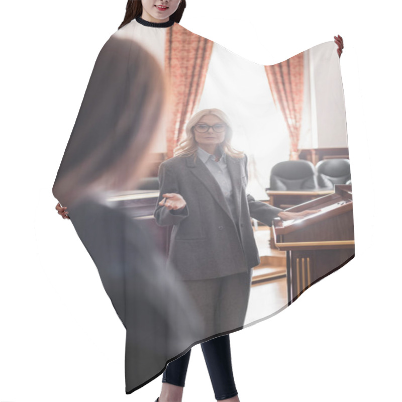 Personality  Blonde Advocate Pointing With Hand While Questioning Blurred Witness In Court Hair Cutting Cape