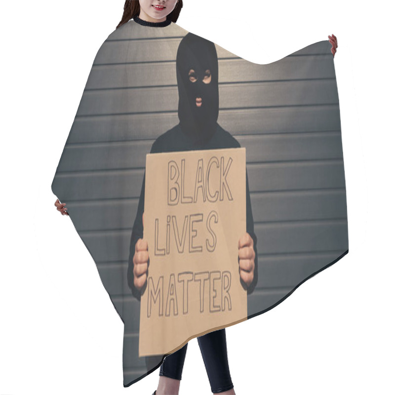 Personality  Man In Balaclava Holding Placard With Black Lives Matter Lettering And Looking At Camera Near Building  Hair Cutting Cape