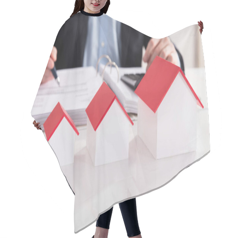 Personality  Businessperson Calculating Bill Behind Different Size Of House Model In A Row Hair Cutting Cape