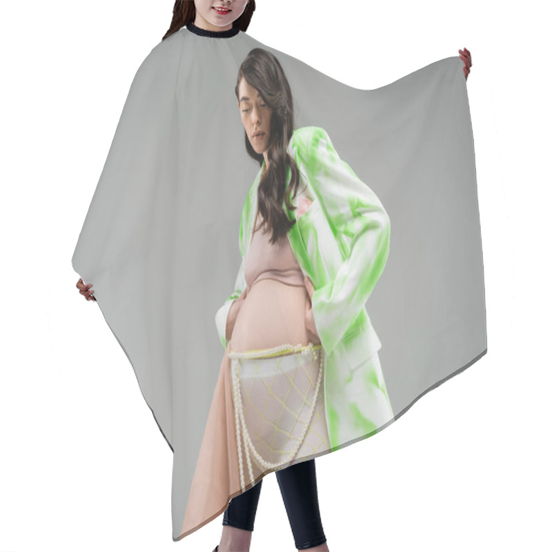 Personality  Low Angle View Of Brunette Mother-to-be In Green And White Blazer, Crop Top, Leggings With Beige Chiffon Cloth And Beads Belt Isolated On Grey Background, Trendy Pregnancy Concept, Expectation Hair Cutting Cape